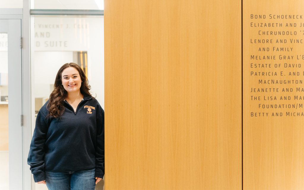 Gilman posing in front of the admissions suite