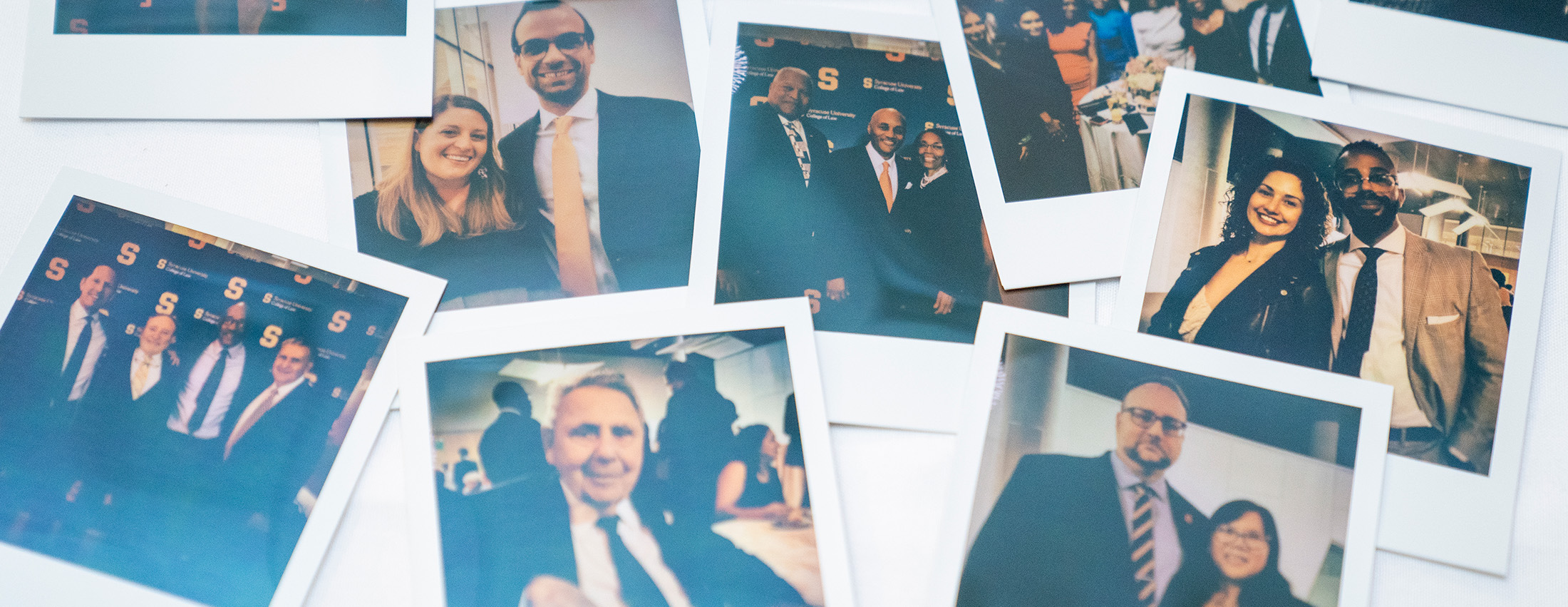 photos of Polaroids taken at law alumni weekend in a heap on a table