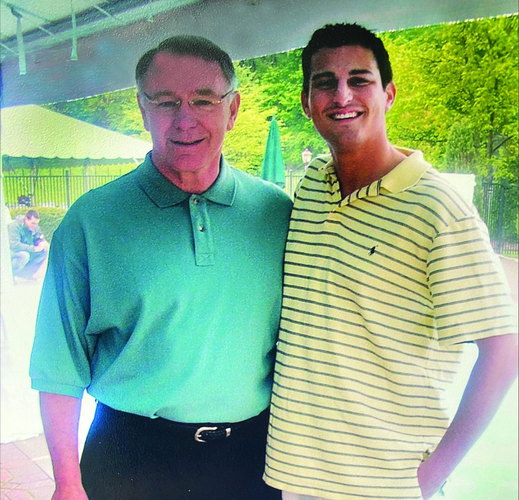 Adam Katz smiles with Judge Mordue both wearing polos in an outdoor setting