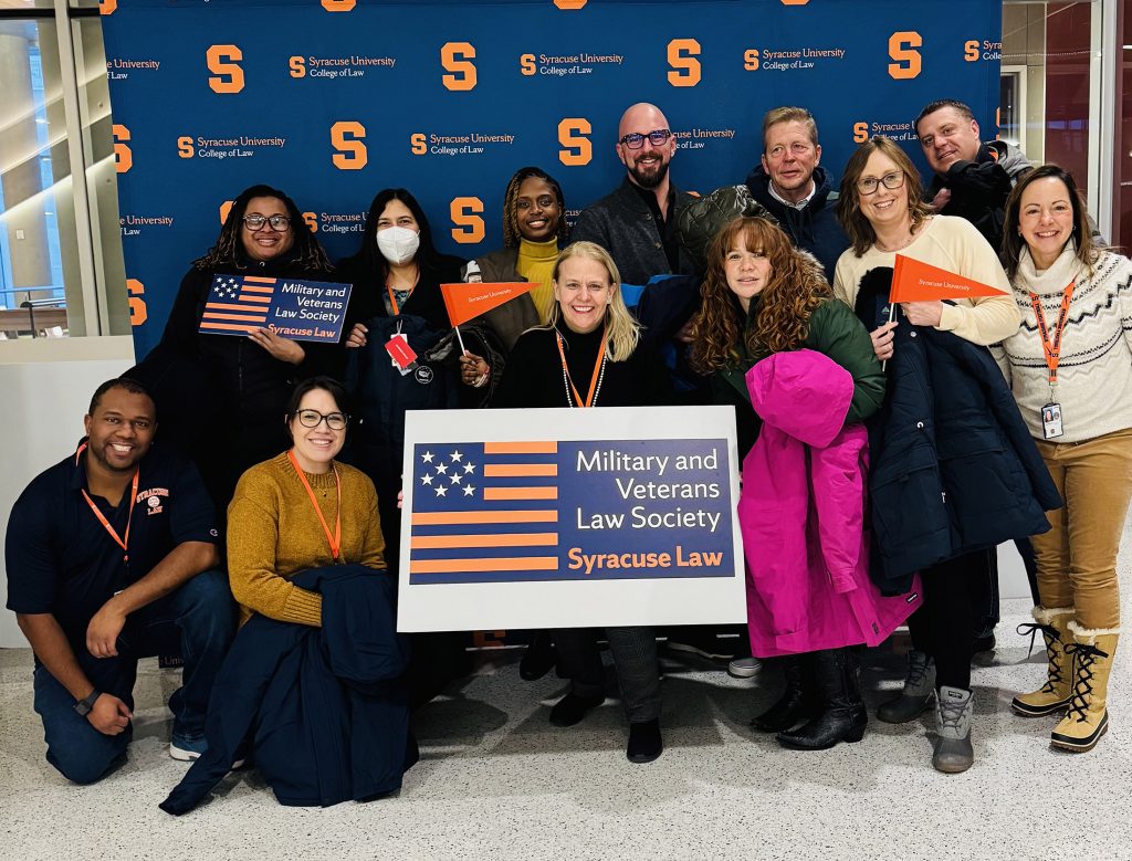 Operation Warm-Up team holding up a Military and Veterans Law Society sign at their event.