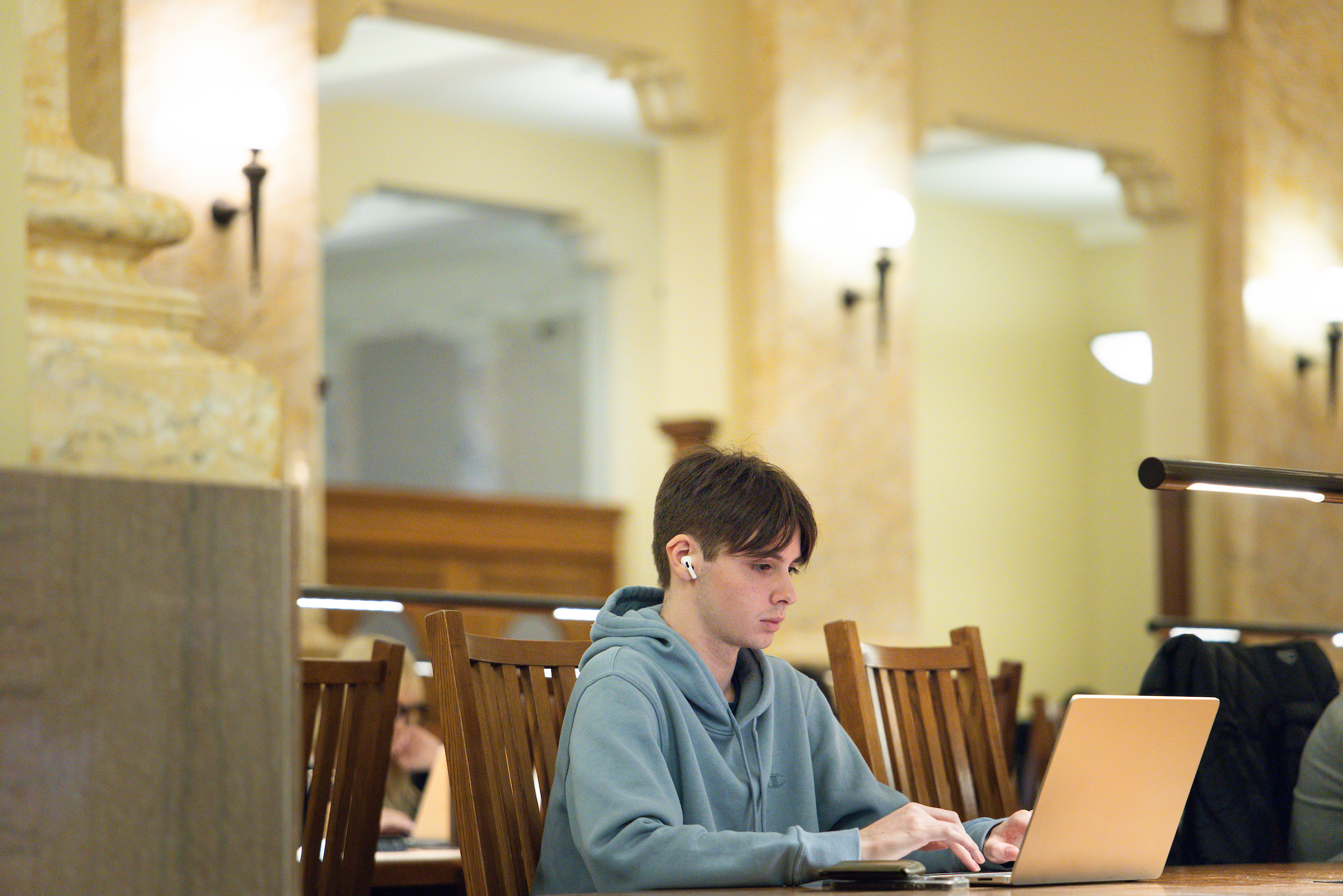 A student on their computer in a library environment. 