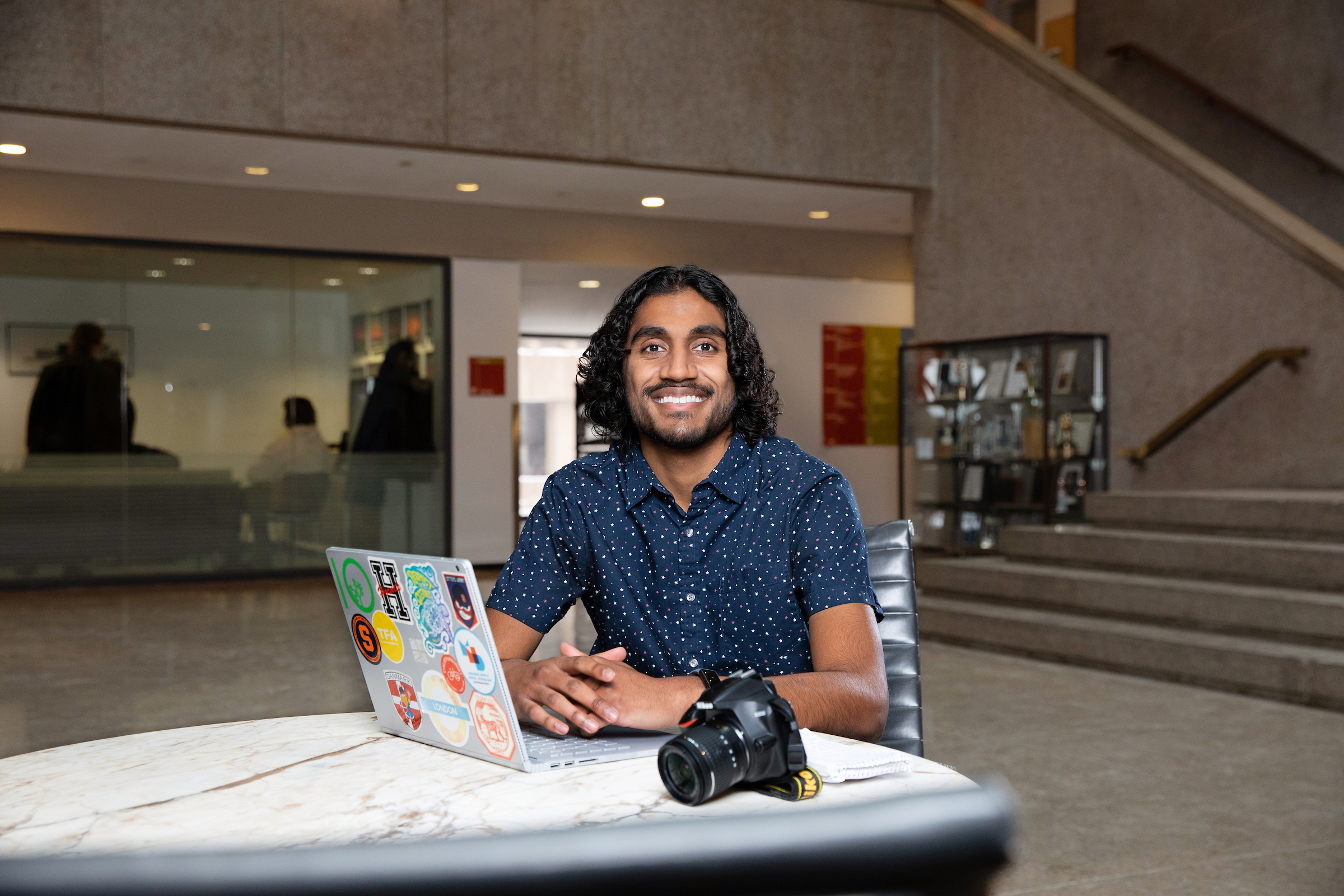 Gaurav Shetty at a computer smiling. 