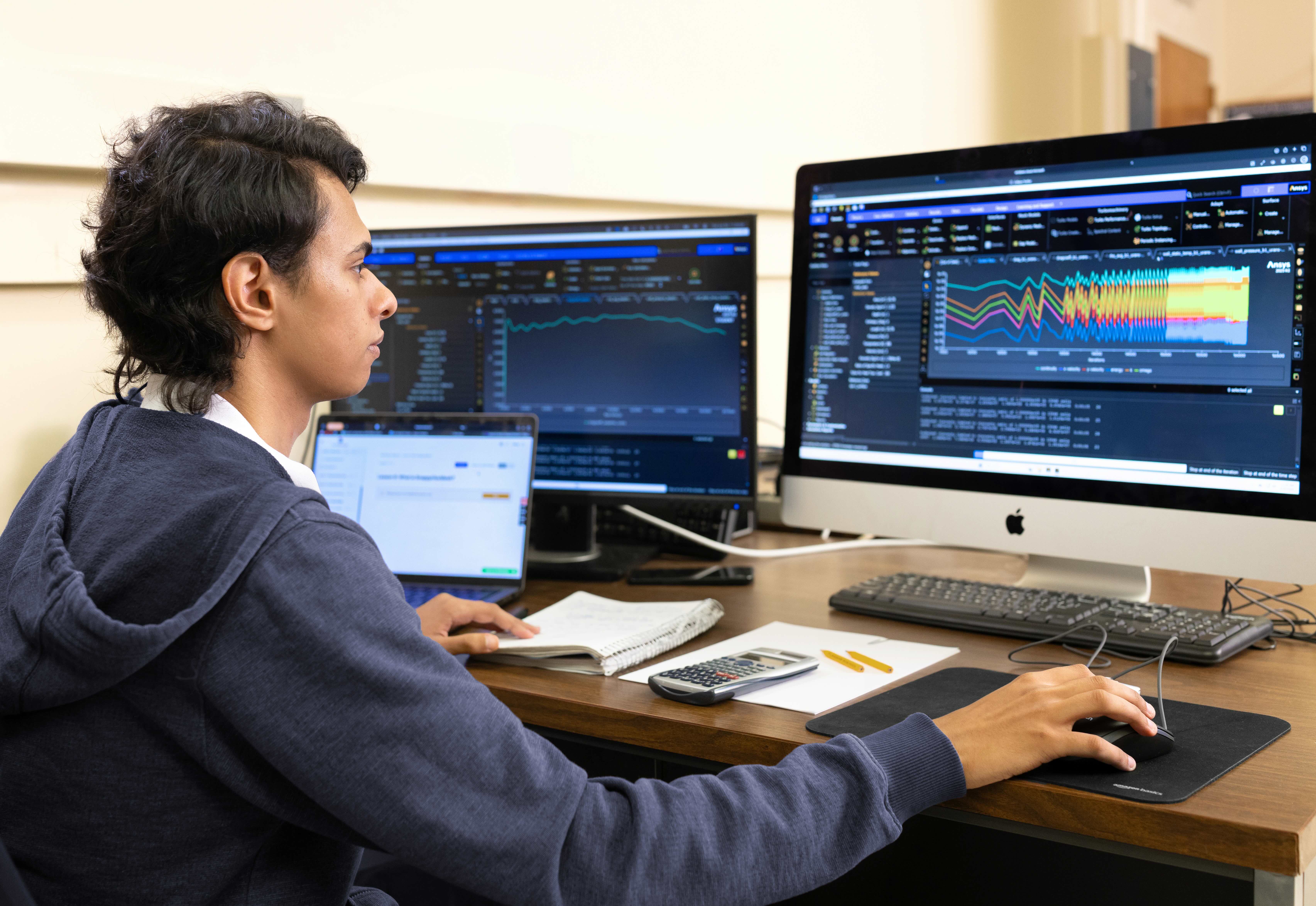 A student looking at his computer working on a project. 