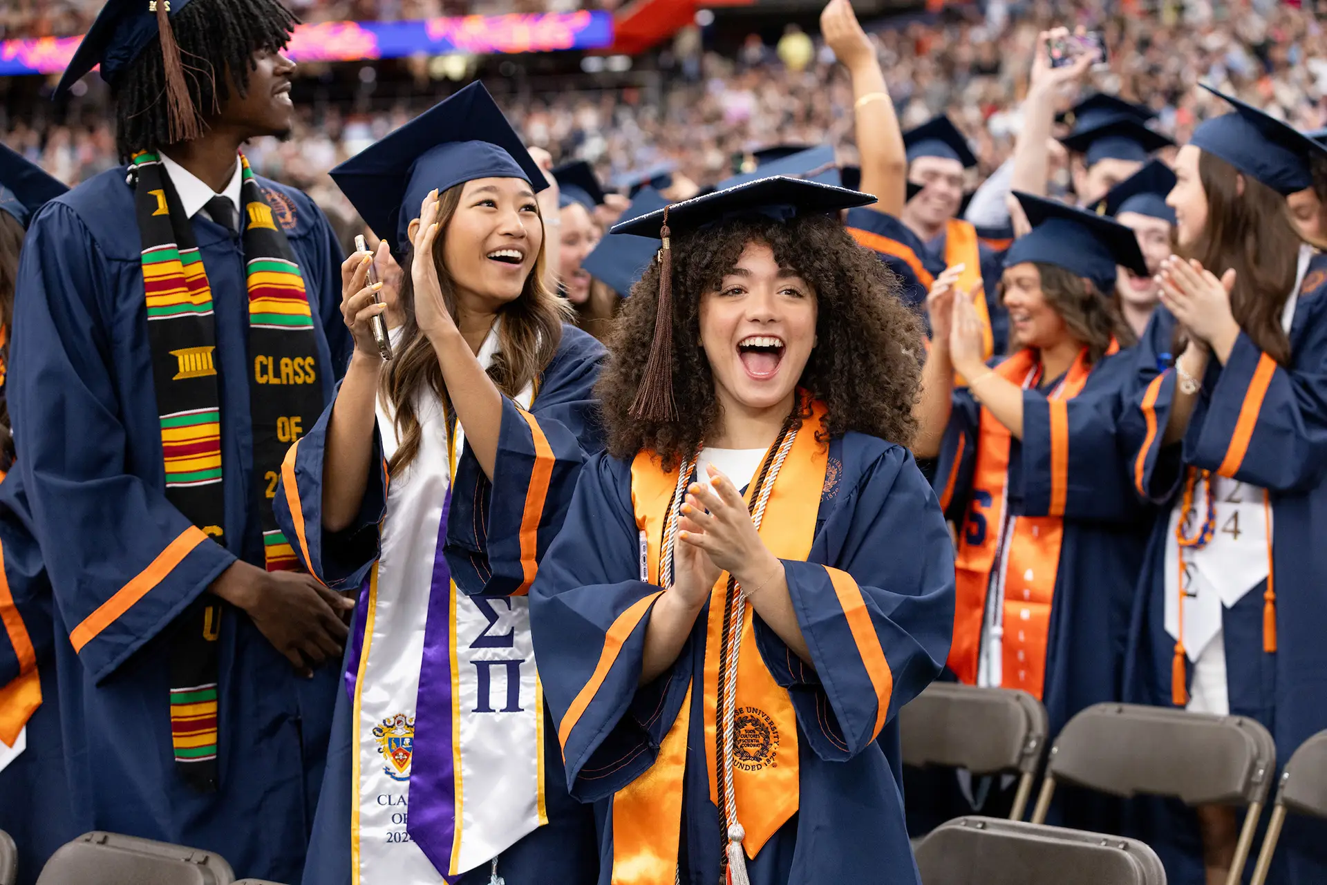 Students in regalia clapping