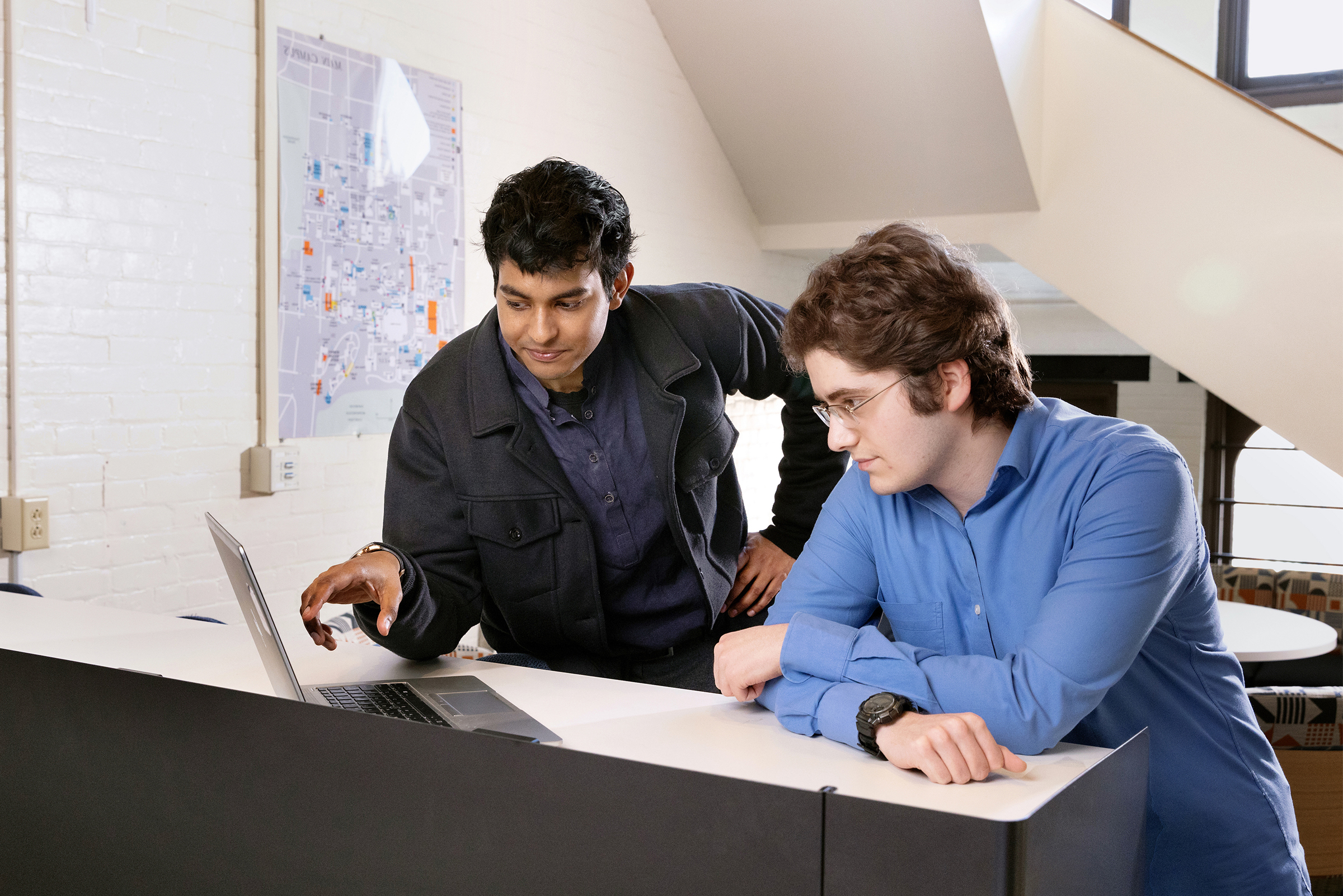 Two students working on a laptop