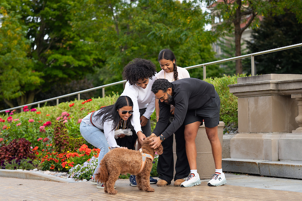Familes, students and a dog explore campus during Family Weekend.